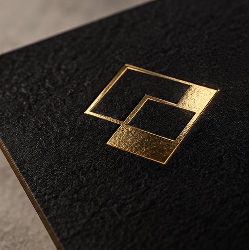 Goldene Folienprägung auf schwarzem Papier